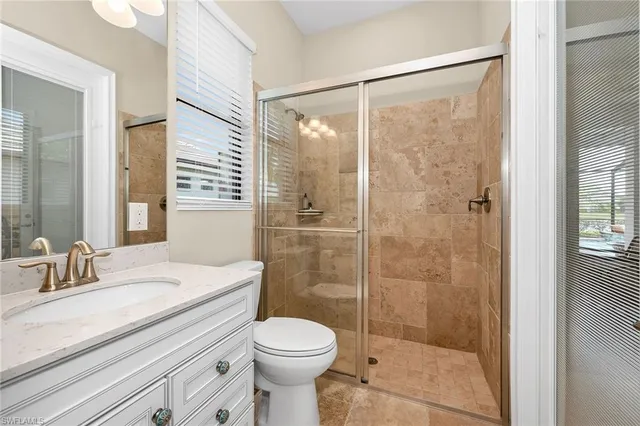 a bathroom with a shower a sink a toilet and shower