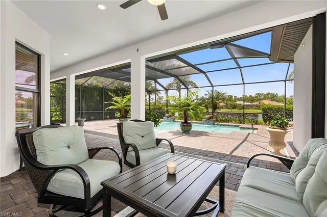 a living room with patio furniture and a floor to ceiling window