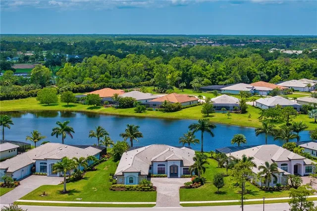 an aerial view of residential houses with outdoor space and lake view