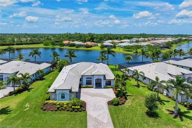 a aerial view of a house with a yard and lake view