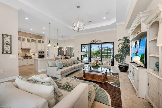 a living room with furniture a flat screen tv and a large window