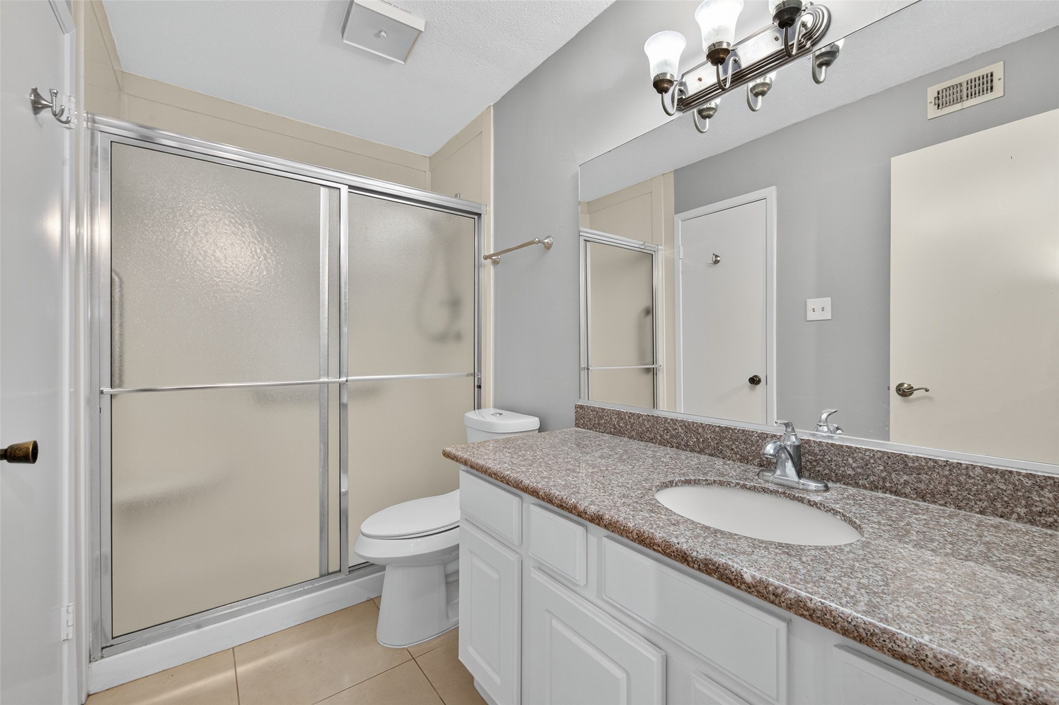 18800 Egret Bay Boulevard, Unit 1207 Webster, TX 77058 - Photo 15 of 30 a bathroom with a granite countertop sink a toilet and shower