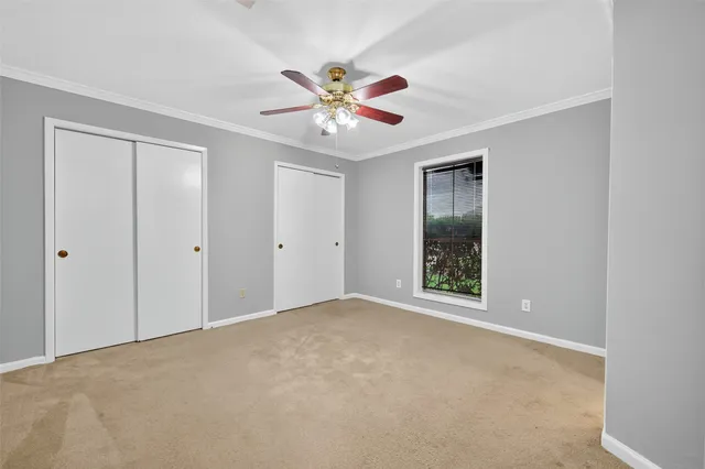 a view of an empty room with window and closet area
