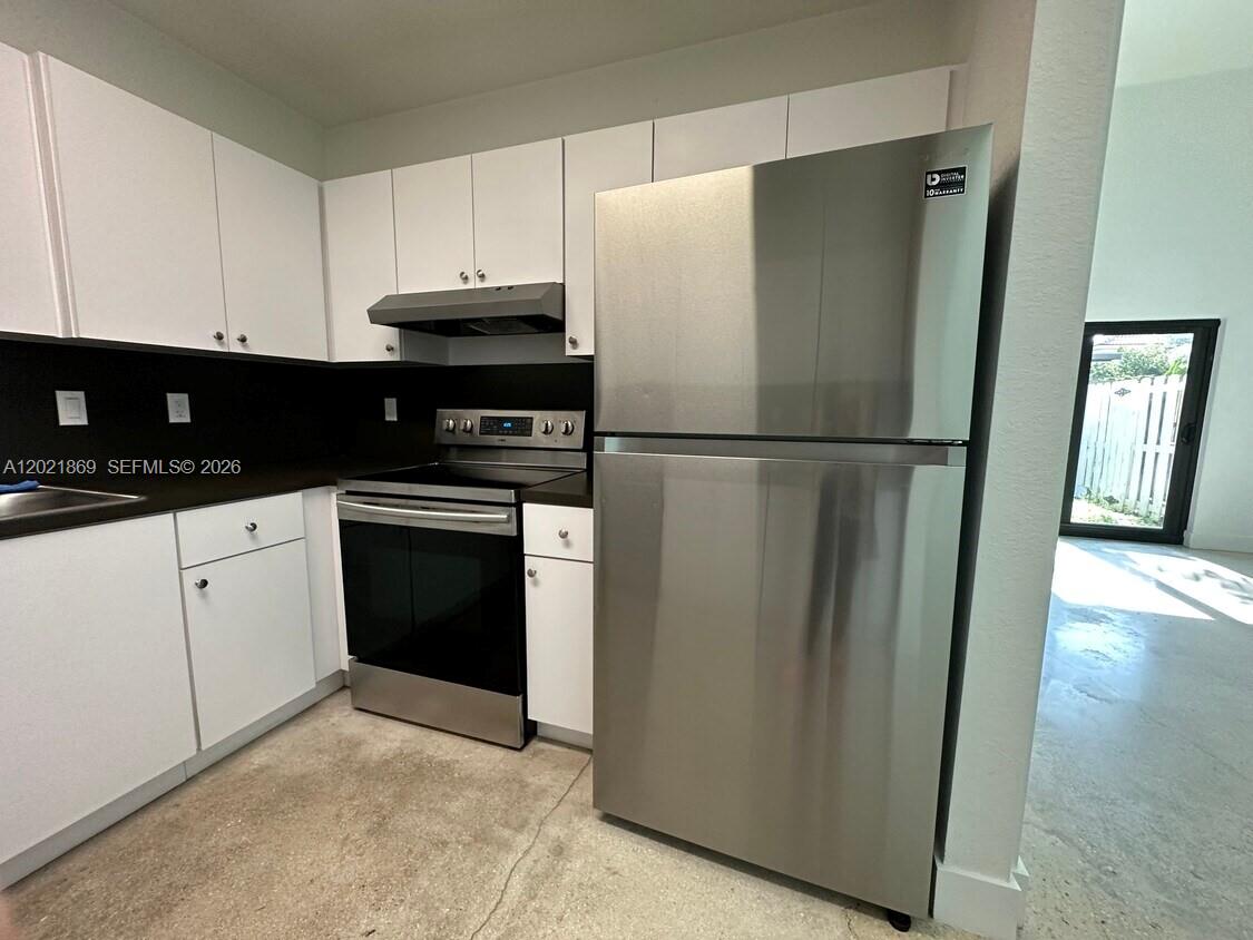23935 Southwest 110th Court, Unit 23935 Homestead, FL 33032 - Photo 7 of 10 a white refrigerator freezer sitting in a kitchen