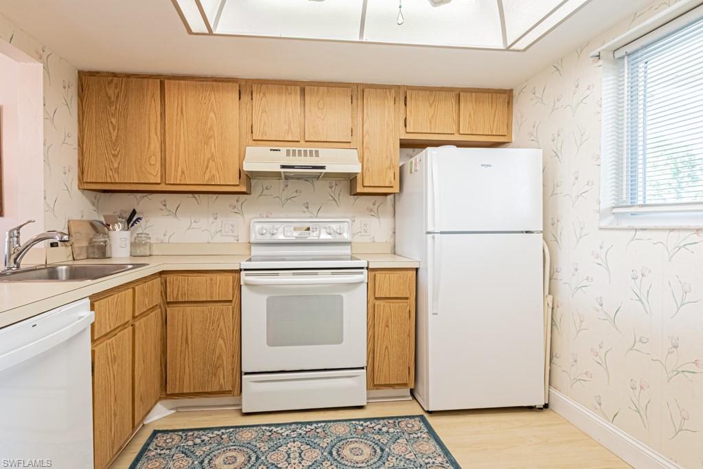1022 Manatee Road, Unit D107 Naples, FL 34114 - Photo 16 of 43 a kitchen with a refrigerator sink stove and cabinets