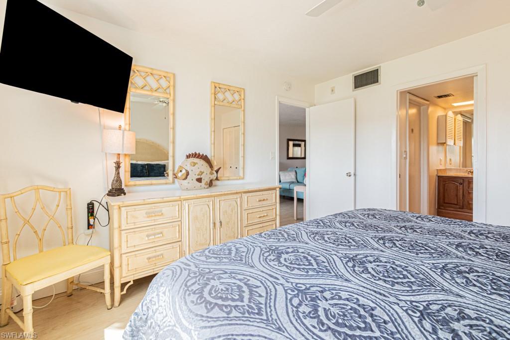 1022 Manatee Road, Unit D107 Naples, FL 34114 - Photo 34 of 43 a bedroom with a bed and a dresser
