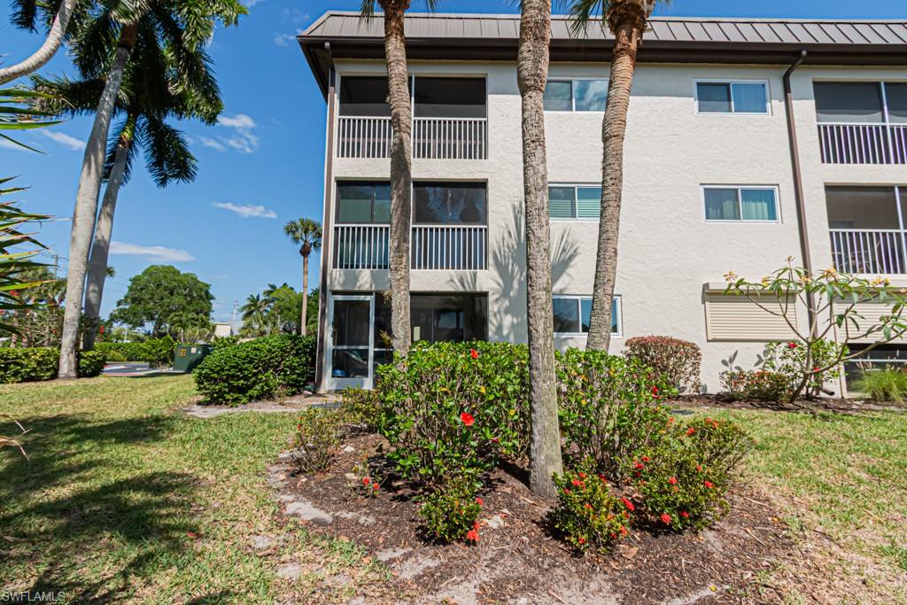 1022 Manatee Road, Unit D107 Naples, FL 34114 - Photo 9 of 43 a front view of a house with a yard
