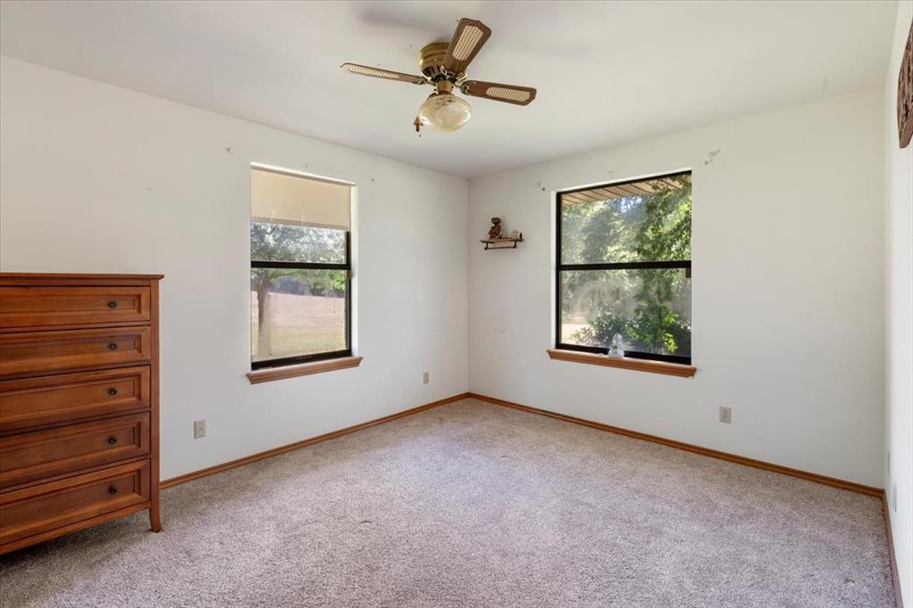 705 West Saunders Street Trenton, TX 75490 - Photo 23 of 37 an empty room with windows and ceiling fan