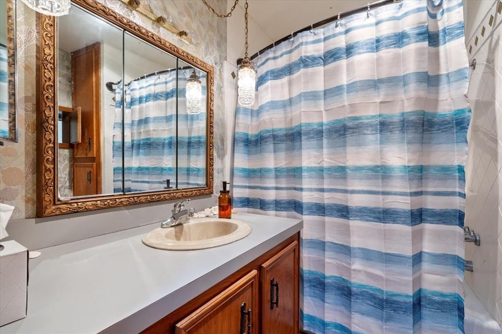 705 West Saunders Street Trenton, TX 75490 - Photo 24 of 37 a bathroom with a sink a mirror and a shower
