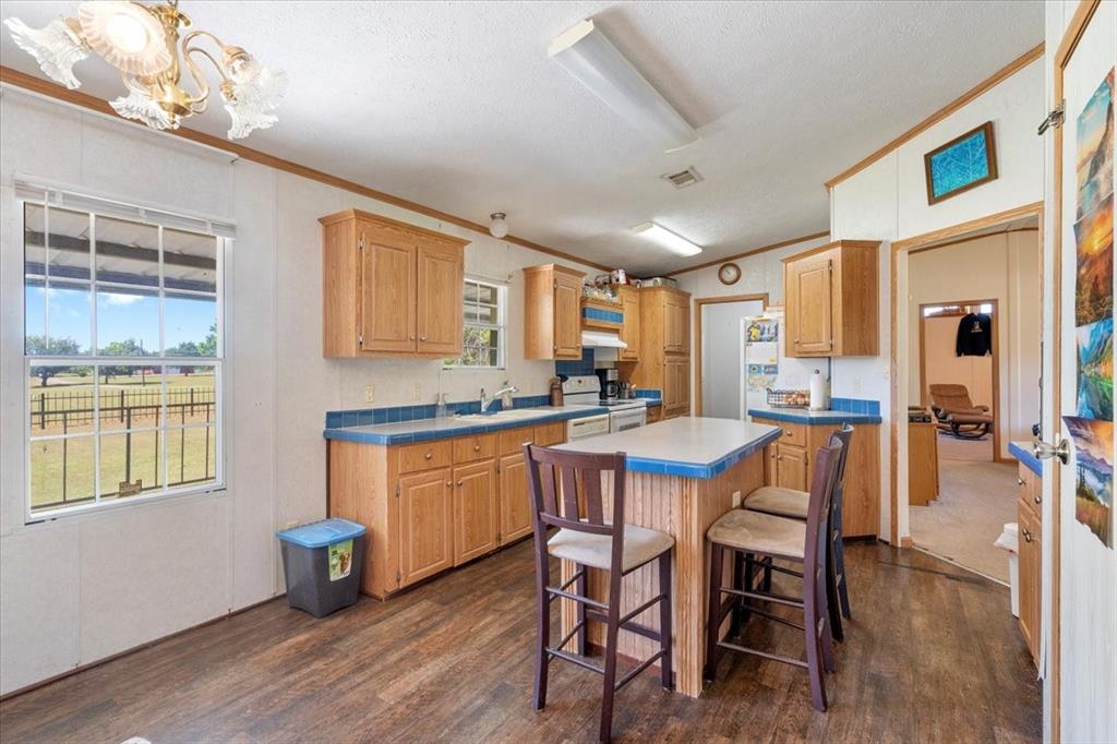 705 West Saunders Street Trenton, TX 75490 - Photo 7 of 37 a dining room with stainless steel appliances kitchen island granite countertop wooden floor a dining table and chairs