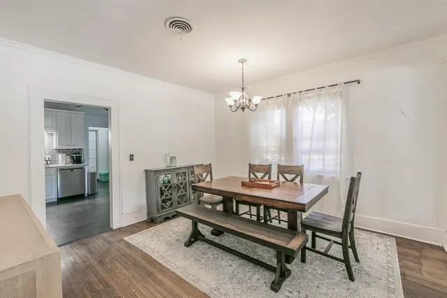 a view of a dining room with furniture wooden floor and chandelier
