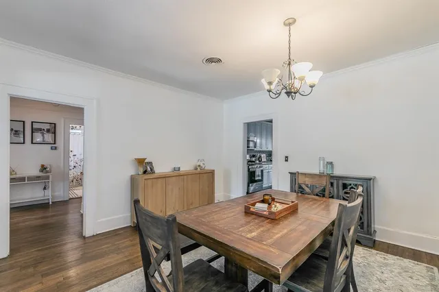 a view of a dining room with furniture a chandelier and wooden floor