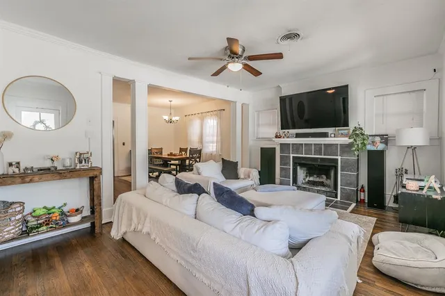 a living room with furniture a fireplace and a flat screen tv