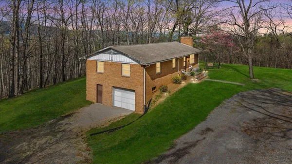 a aerial view of a house next to a big yard and large trees