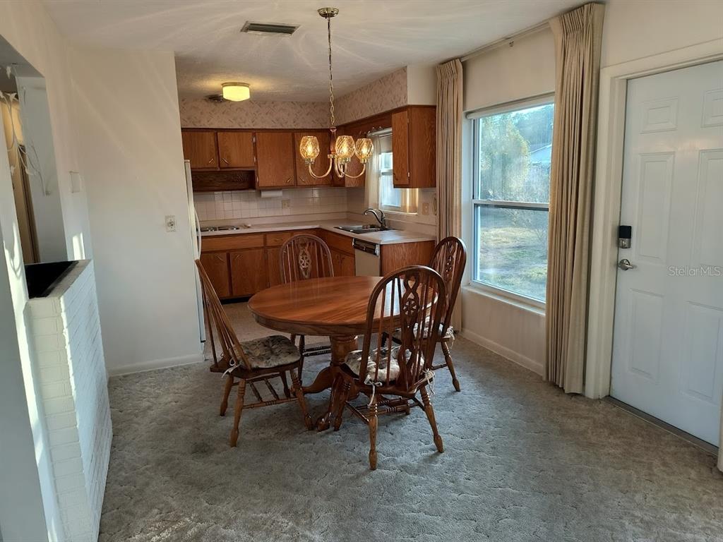 732 Keene Road Largo, FL 33771 - Photo 6 of 38 a view of a dining room with furniture and a chandelier