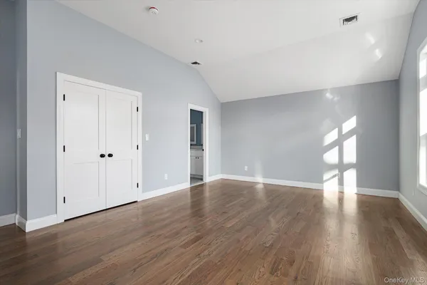 a view of an empty room with wooden floor