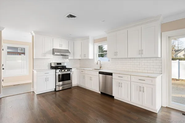 a kitchen with granite countertop white cabinets and white appliances