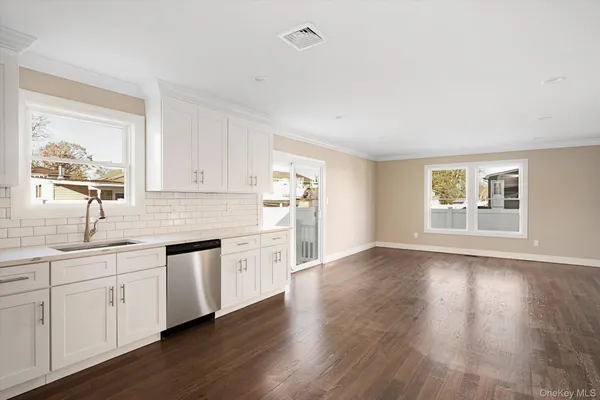 a kitchen with a sink cabinets and wooden floor