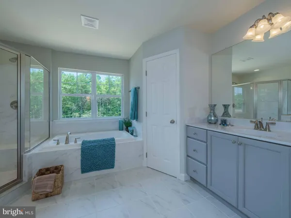 a spacious bathroom with a tub sink and mirror