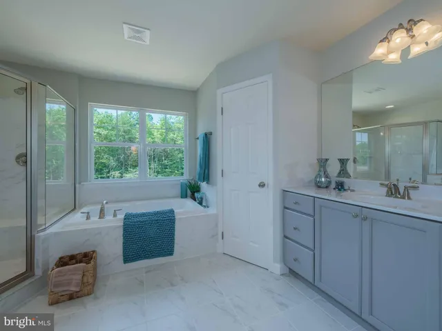 a spacious bathroom with a tub sink and mirror