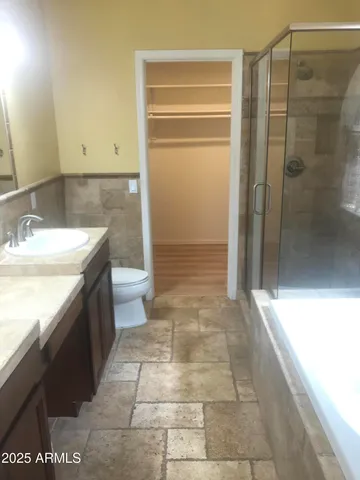 a bathroom with a granite countertop sink a toilet and a shower
