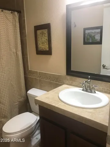 a bathroom with a toilet a sink and mirror