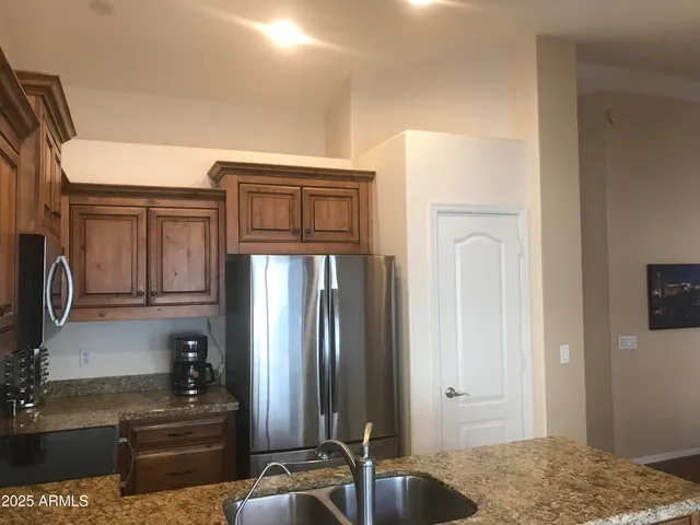 a kitchen with granite countertop a refrigerator and a sink