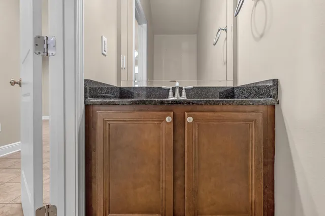 a bathroom with a granite countertop sink and a mirror