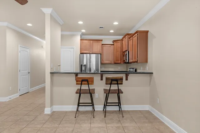 a kitchen with stainless steel appliances kitchen island granite countertop a refrigerator and cabinets