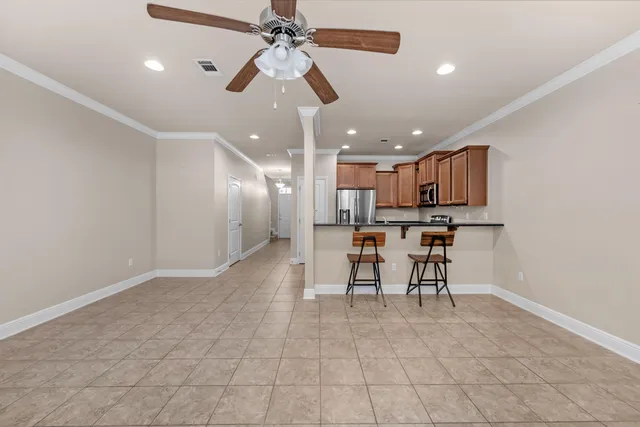 a view of kitchen with stainless steel appliances refrigerator stove microwave and cabinets