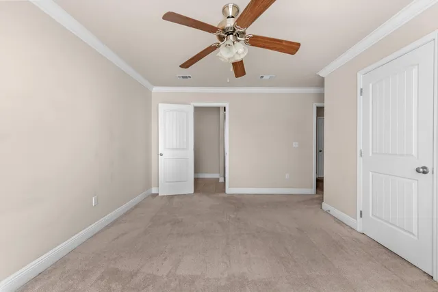 an empty room with closet and a ceiling fan