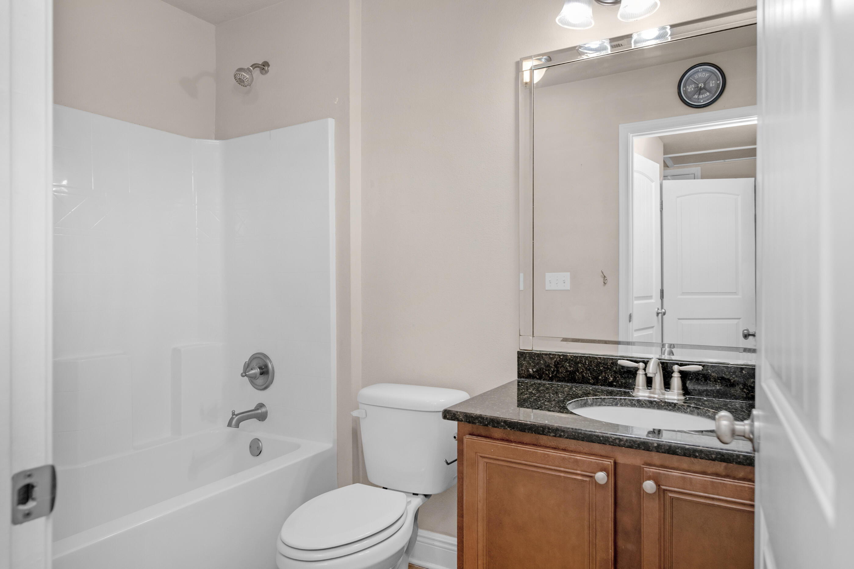 19 East Shady Oaks Lane, Unit E Santa Rosa Beach, FL 32459 - Photo 32 of 33 a bathroom with a granite countertop sink toilet and shower