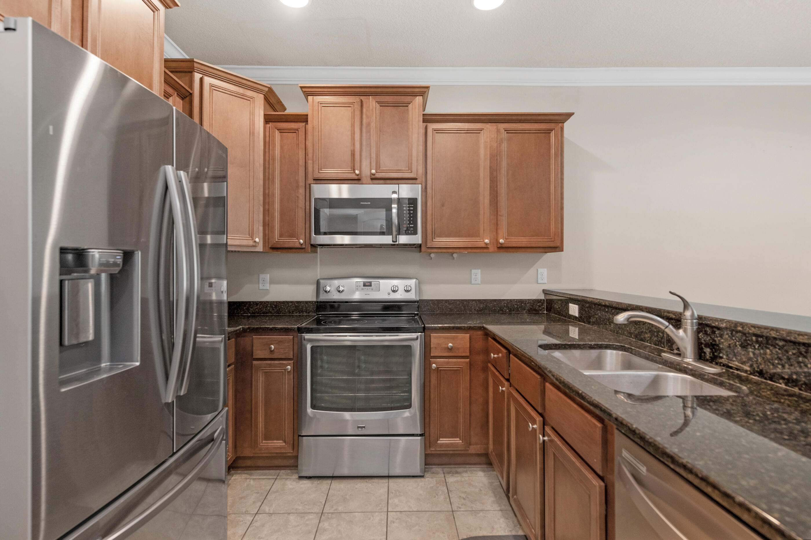 19 East Shady Oaks Lane, Unit E Santa Rosa Beach, FL 32459 - Photo 5 of 33 a kitchen with stainless steel appliances granite countertop a stove a sink and a refrigerator
