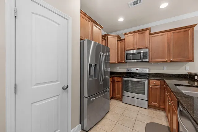 a kitchen with stainless steel appliances granite countertop a refrigerator stove and sink