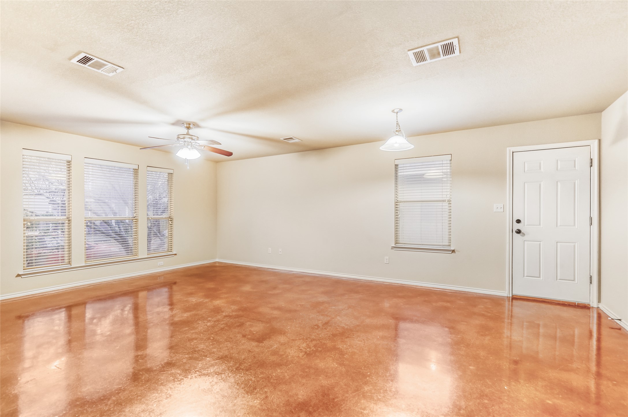 4620 Best Way Austin, TX 78725 - Photo 3 of 11 Empty room featuring a ceiling fan, finished concrete flooring, and a textured ceiling