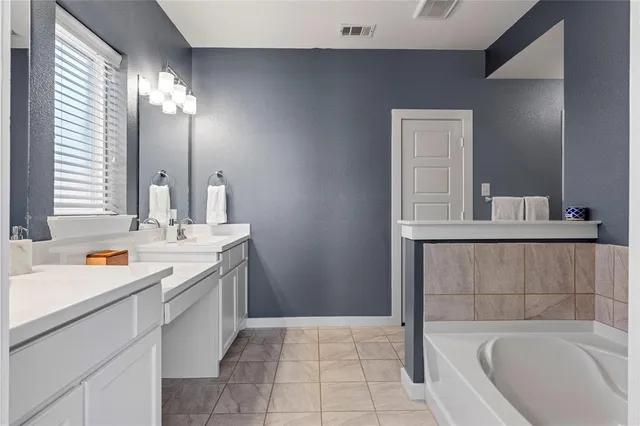 a bathroom with a tub sink and mirror