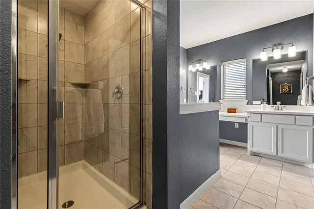 a bathroom with a double vanity sink a toilet and shower