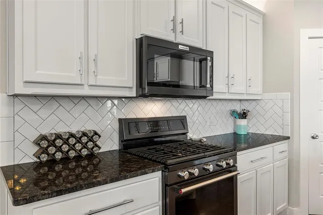 a kitchen with white cabinets and appliances