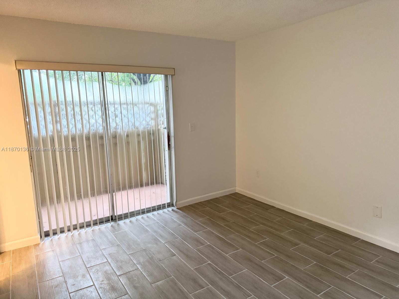8500 Southwest 109th Avenue, Unit 6118 Miami, FL 33173 - Photo 3 of 15 an empty room with wooden floor and windows