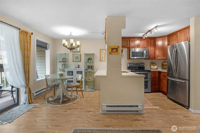 a kitchen with stainless steel appliances kitchen island granite countertop a refrigerator cabinets and wooden floor