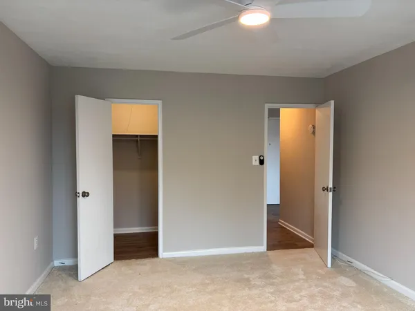 an empty room with closet and mirror