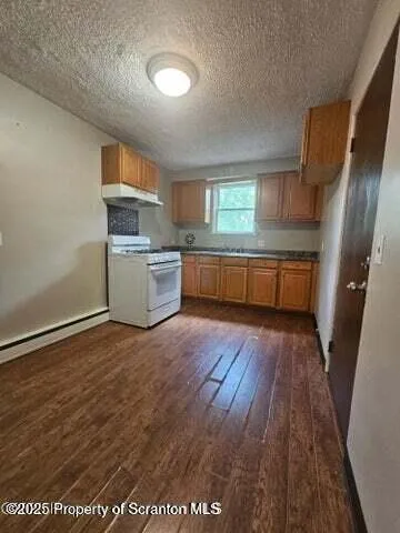 a kitchen with a wooden floor and electronic appliances
