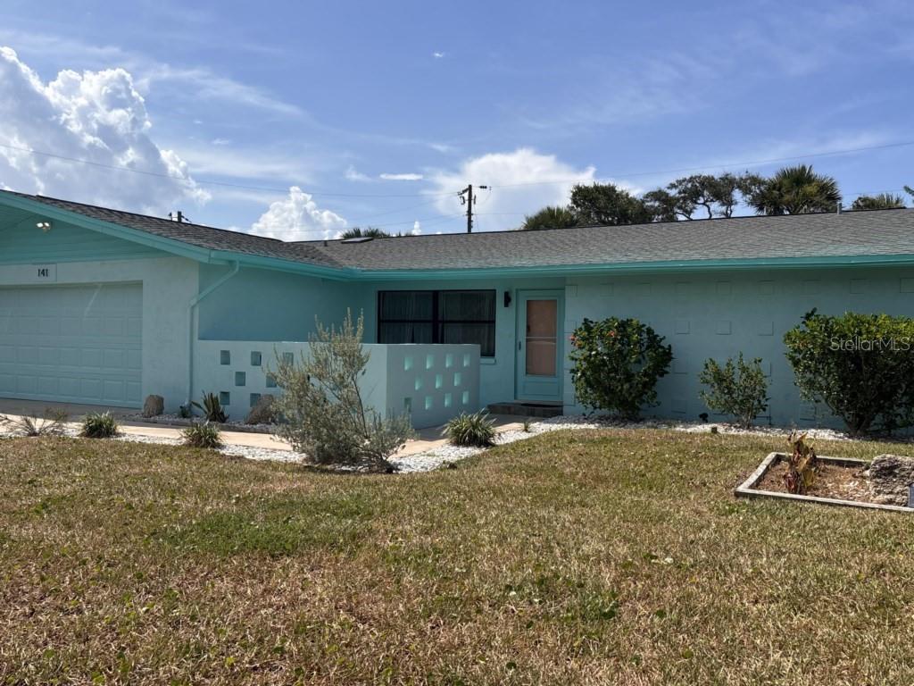 a view of a house with backyard and sitting area