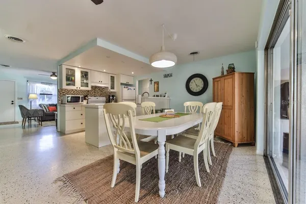 a view of a dining room and livingroom with furniture wooden floor a rug a fireplace