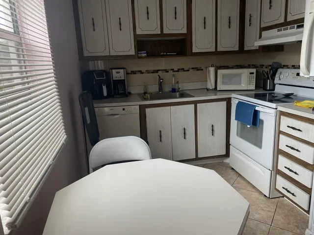 a kitchen with stainless steel appliances a sink a stove a microwave cabinets and a refrigerator