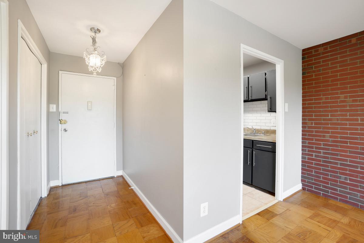 1900 Lyttonsville Road, Unit 1101 Silver Spring, MD 20910 - Photo 2 of 24 a view of a hallway with wooden floor and a living room