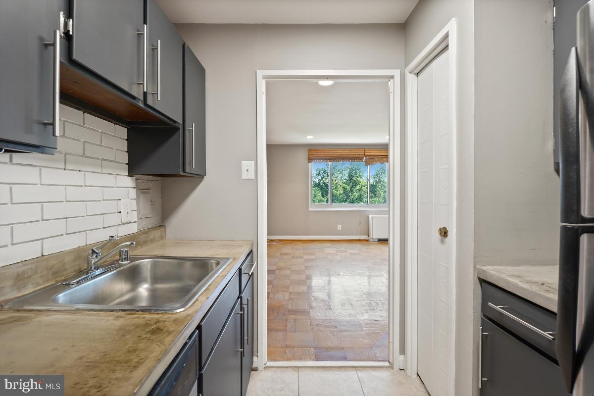 1900 Lyttonsville Road, Unit 1101 Silver Spring, MD 20910 - Photo 6 of 24 a kitchen with a sink a stove and a refrigerator with wooden floor