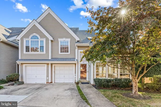 a view of a white house with a large tree