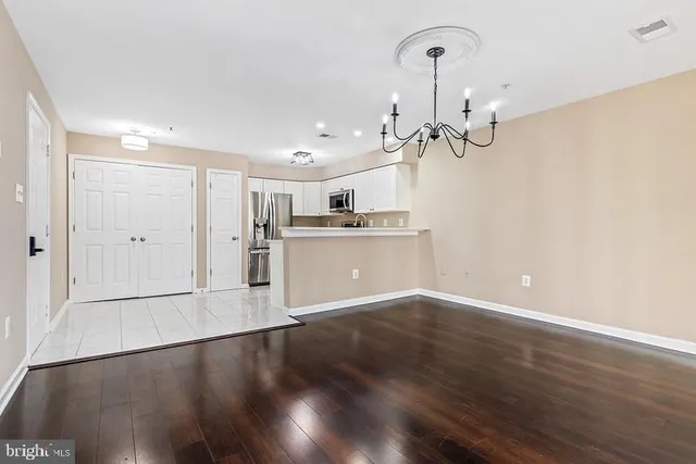 a view of a kitchen with refrigerator and wooden floor