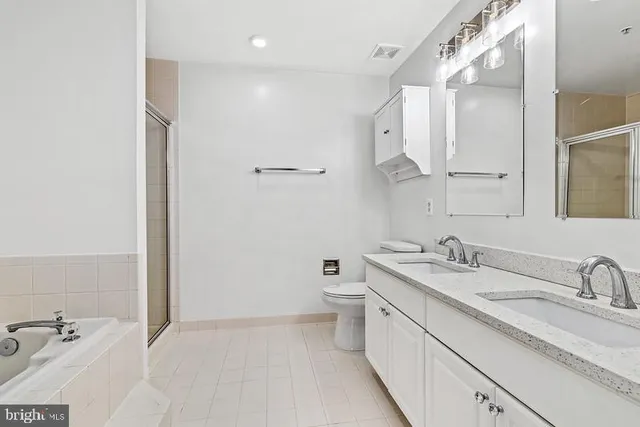 a spacious bathroom with a granite countertop sink mirror and toilet